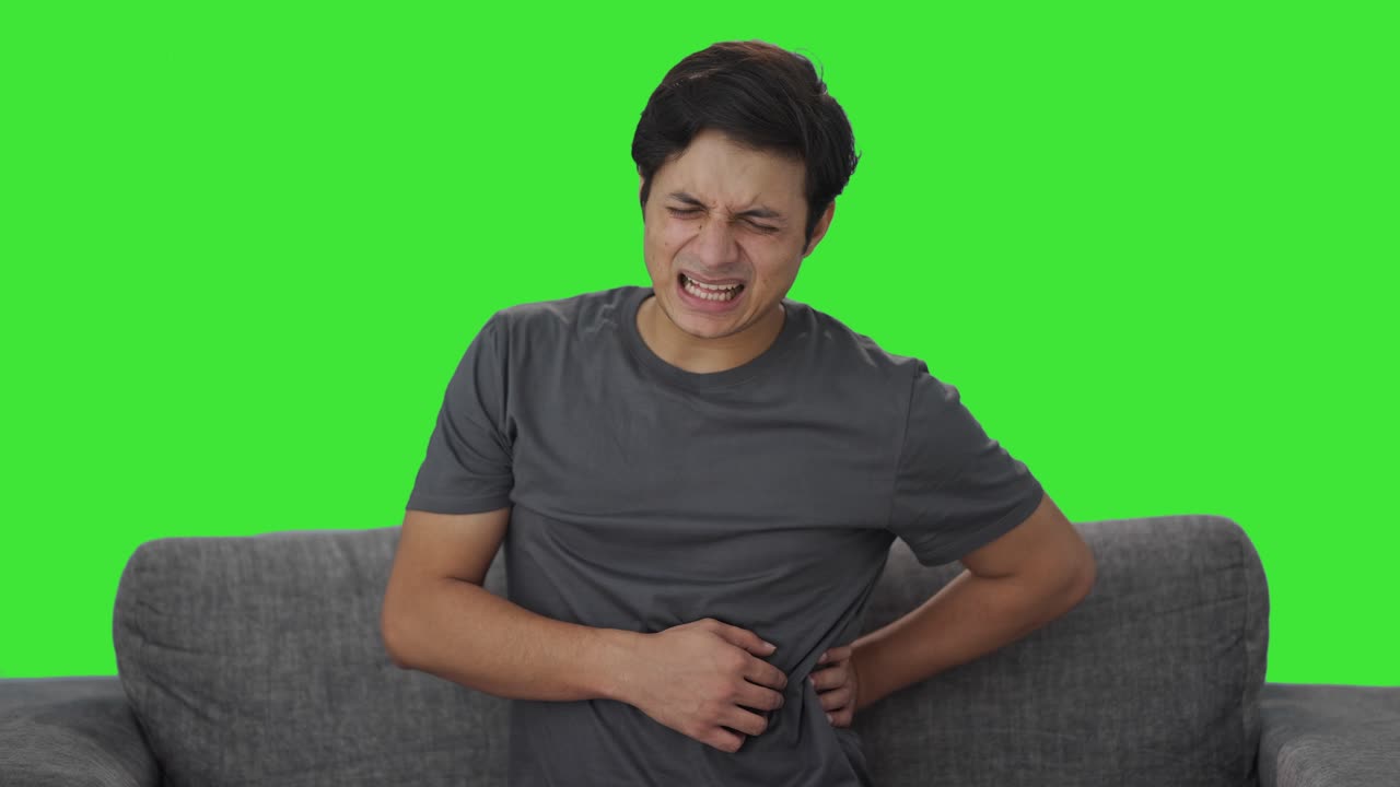 Sick Indian man suffering from back pain Green screen