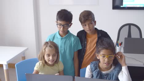 School-boys-and-girls-sitting-and-standing-at-desk