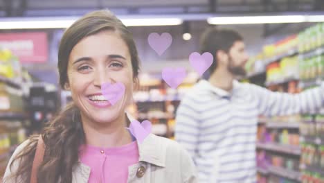 animación de iconos de corazones cayendo sobre una pareja caucásica en la tienda