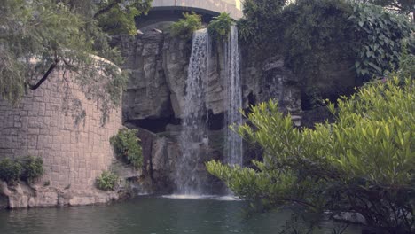 waterfall near a little lake in a park during the day