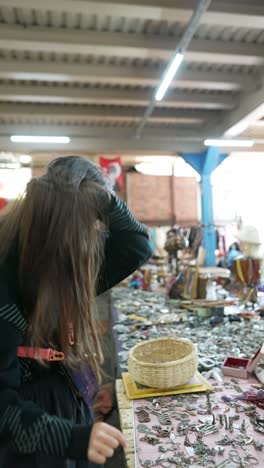 woman looking at keychains in a market