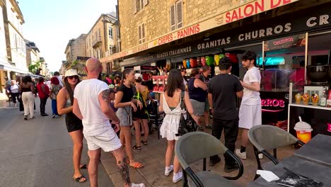 people enjoying food stalls in a busy street