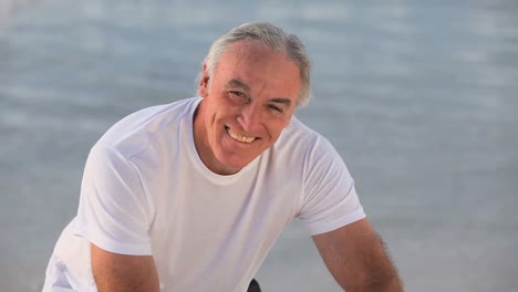 elderly man posing in front of the camera with a bike