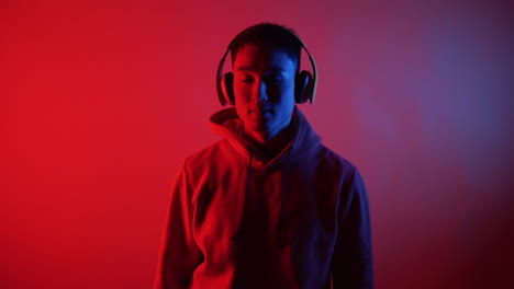 young man listening to music in neon lights