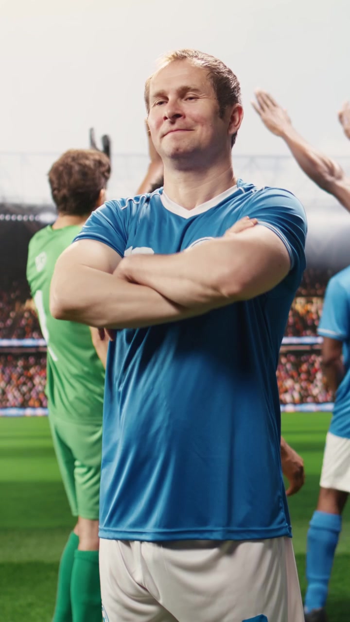 Video verticale: Ritratto di un giocatore in maglia blu che saluta i tifosi e posa con sicurezza.