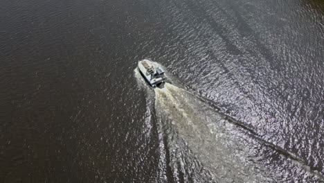 aerial drone birds eye view of a motorboat on the kennebec river in bath, maine