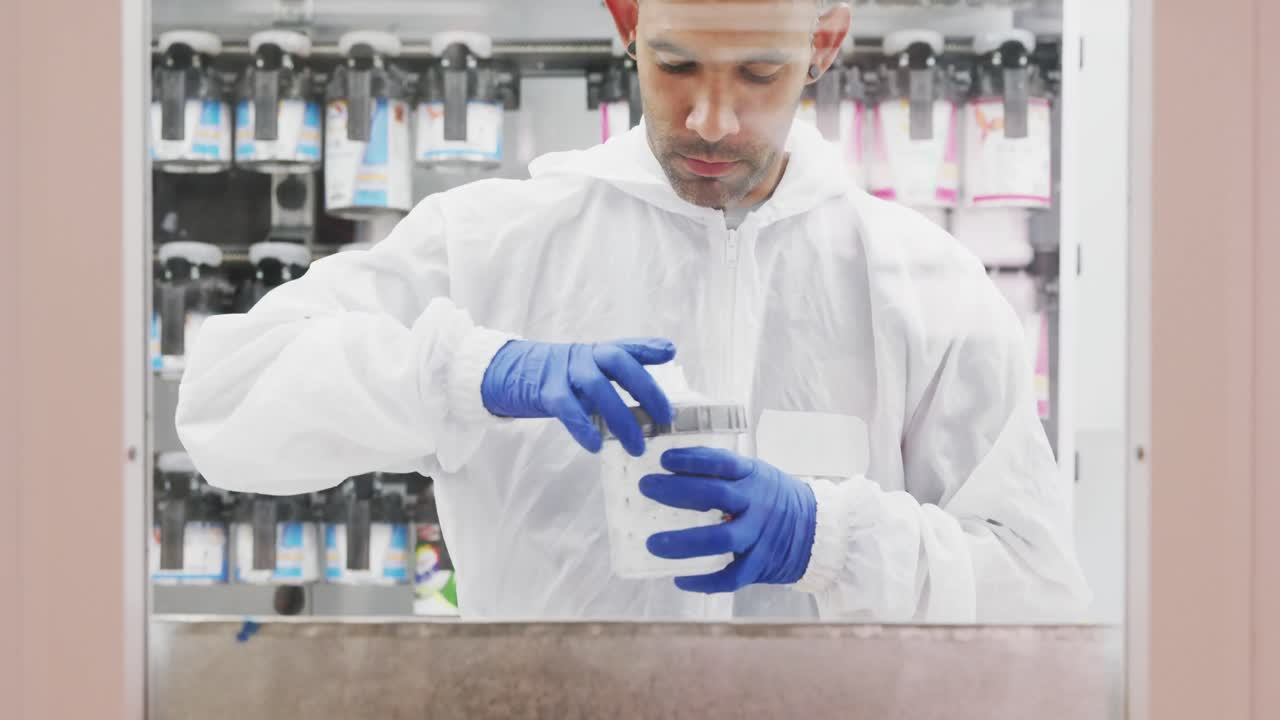 Caucasian male car mechanic filling a spraying gun