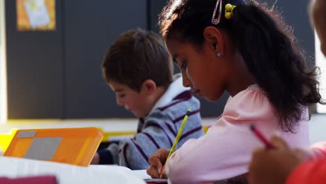 Attentive-schoolkids-doing-their-homework-in-classroom