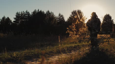 Silhouette-Of-A-Man-In-Camouflage-Fatigues-And-Ammunition-It-Goes-On-A-Country-Road-In-Arms