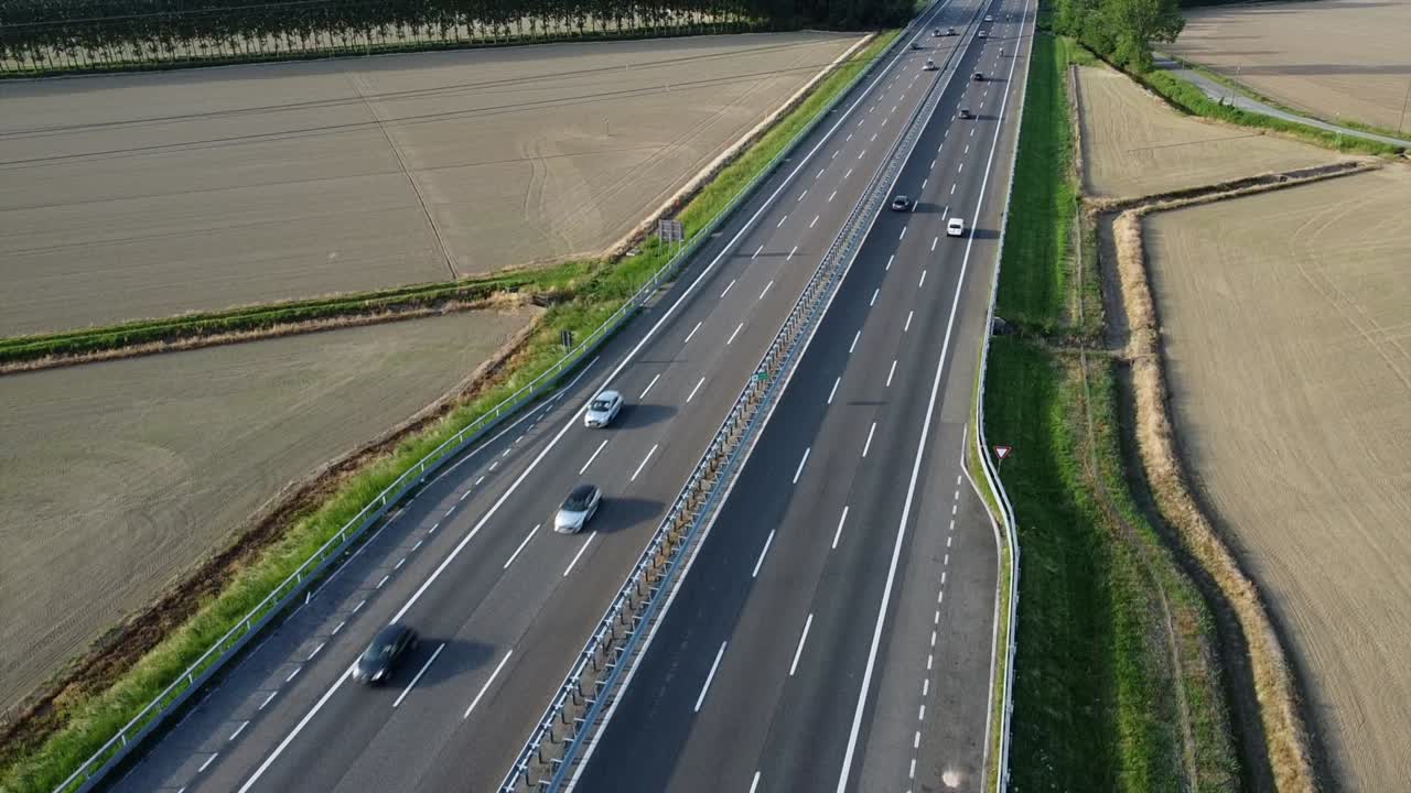 view from the drone of a new light pylon for the passage of high voltage electricity in countryside landscape and traffic car highway - increase in the cost of electricity energy  and green revolution