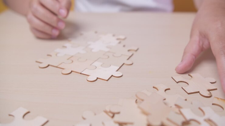 Businesswoman hand connecting jigsaw puzzle with sunlight effect, Business solutions, success, and strategy concept