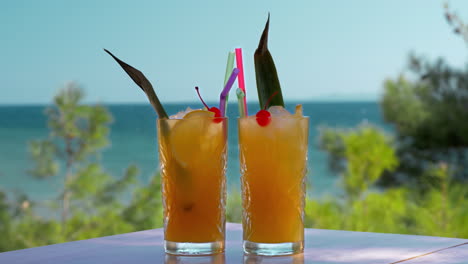 two glasses of iced fruit drinks on sea background vacation time