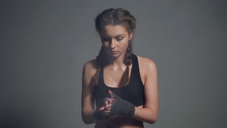 Joven-Y-Hermosa-Mujer-En-Forma-Espolvoreándose-Las-Manos-Envueltas-En-Cintas-De-Boxeo-Mientras-Se-Prepara-Para-Hacer-Ejercicio-En-El-Gimnasio