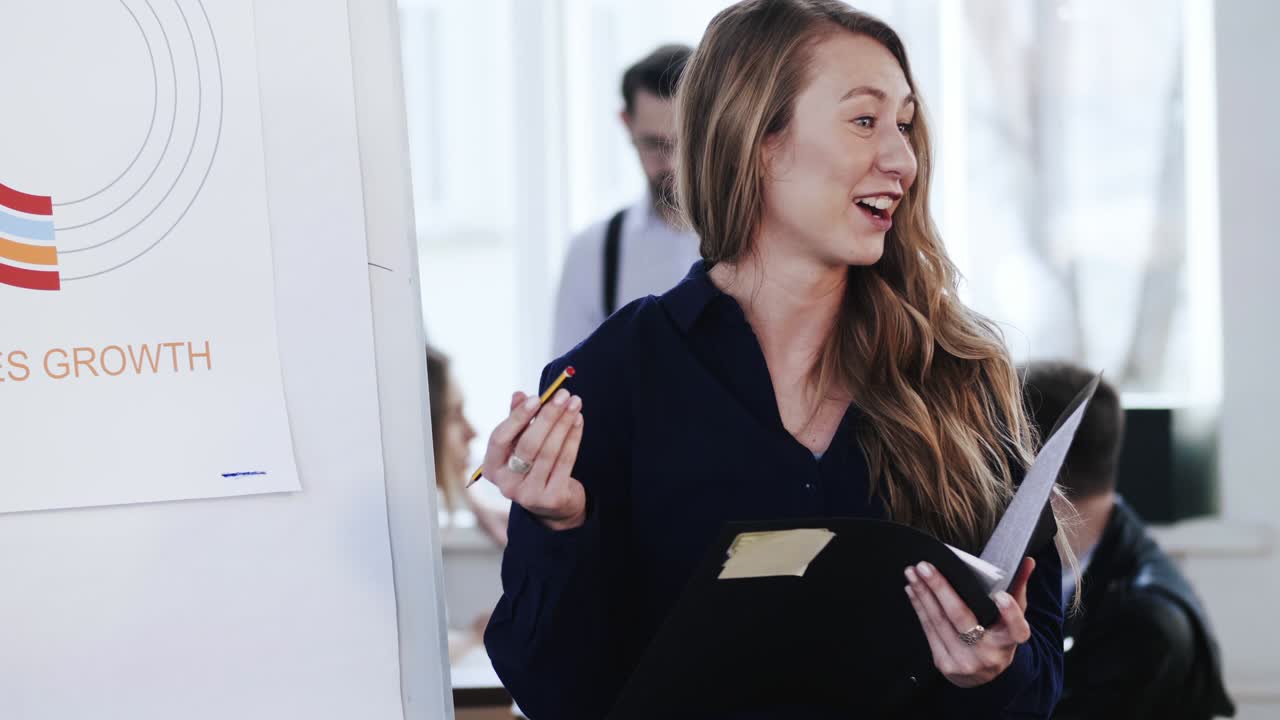 젊은 행복한 백인 ceo 사업가 여성이 브리프케이스를 들고 사무실 회의에서 동료들에게 금융 다이어그램을 설명하고 있습니다.