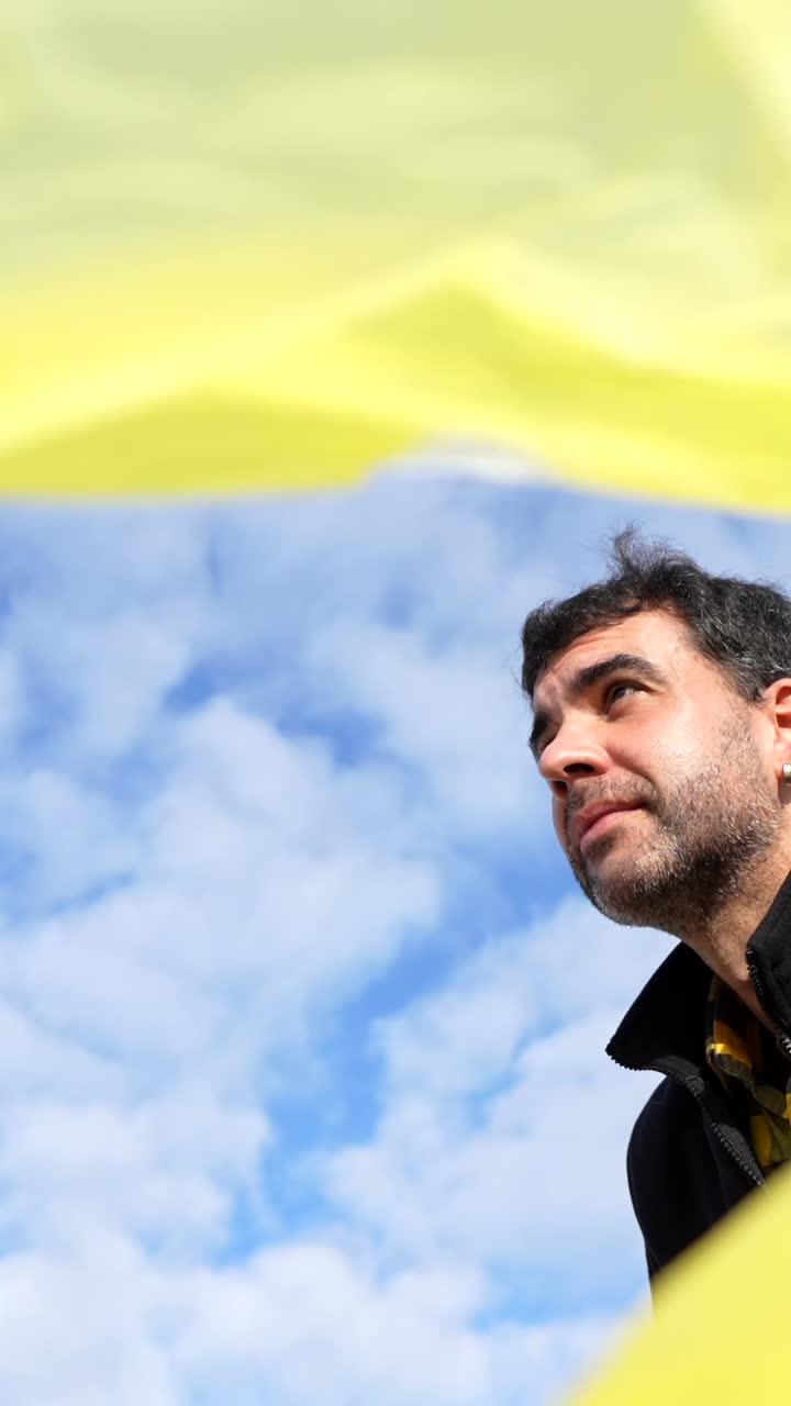Person in black jacket against blue sky and clouds