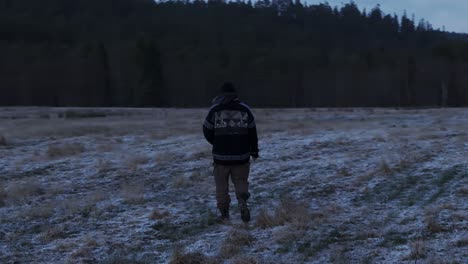 man roaming on dry farm field with snow during autumn in indre fosen, norway