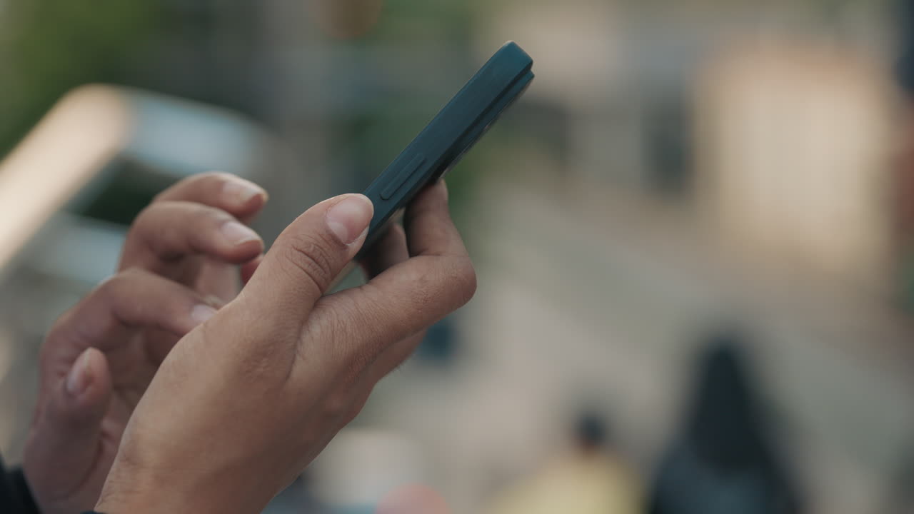persona que utiliza un teléfono inteligente al aire libre