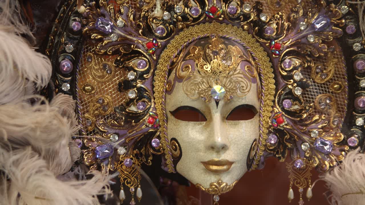 Primo piano di una maschera decorativa del Carnevale veneziano adornata con gemme e piume