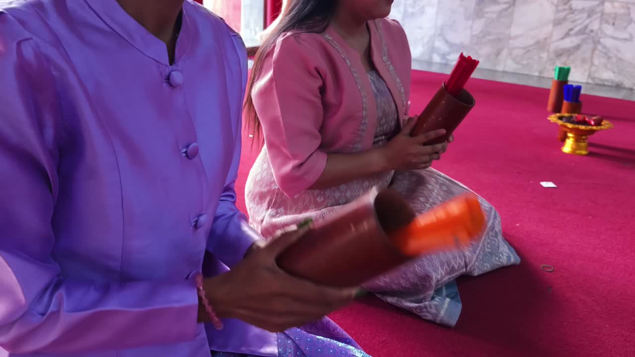 ceremonia religiosa tailandesa con palos de incienso