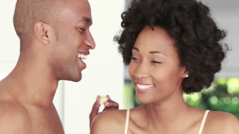 pareja romántica sonriente tomando el desayuno juntos