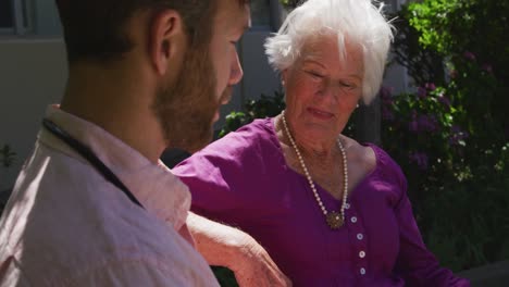 doctor with a senior woman in the park of a retirement home
