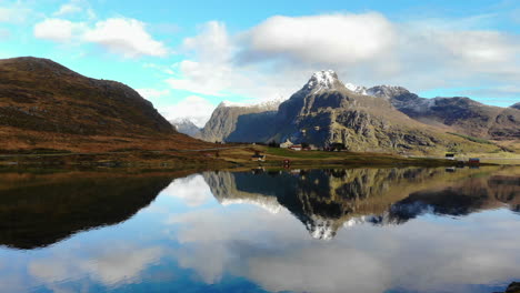 Drone-flys-backwards,-revealing-a-mountain-and-a-lake