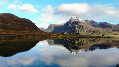 drone flys backwards, revealing a mountain and a lake