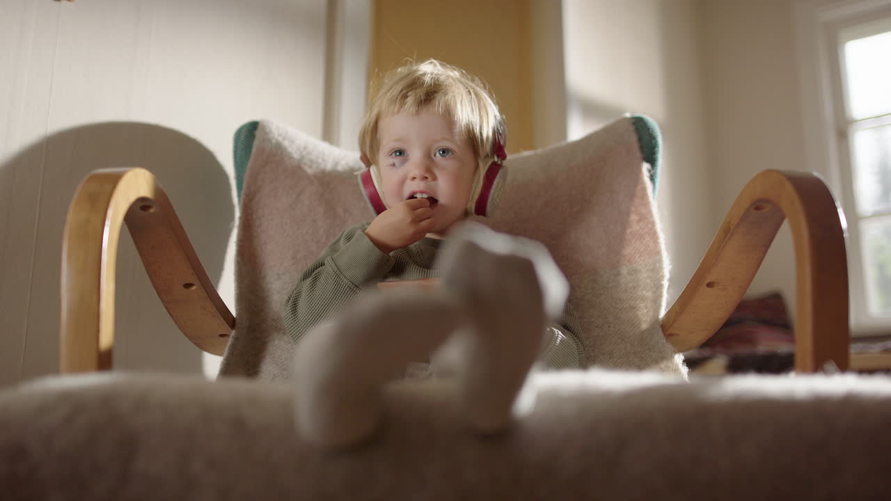 Adorable Toddler Boy Eating in Rocking Chair