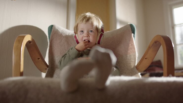 Adorable Toddler Boy Eating in Rocking Chair