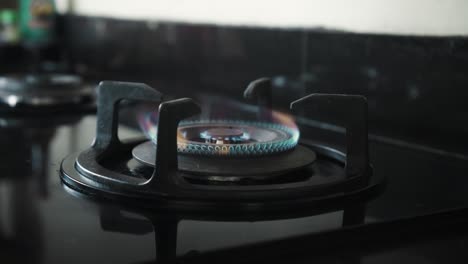 video of a black gas stove with blue and red burning flame in the kitchen