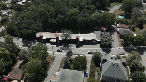 Cars-Driving-In-National-Road-Surrounded-By-Trees-And-Buildings-Located-In-St