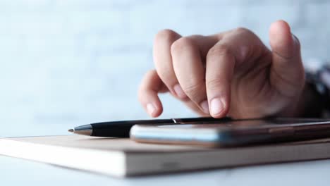 persona que utiliza un teléfono inteligente y toma notas