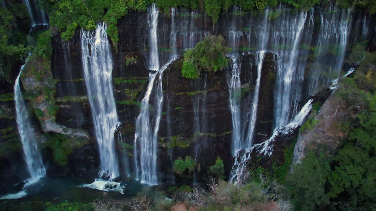 Ampia ripresa aerea in allontanamento di una cascata in Michoacán, Messico, circondata da una lussureggiante vegetazione