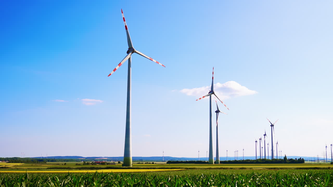 Turbines producing green energy. Wind turbines tower over green fields, harnessing wind energy on a clear day in a rural area