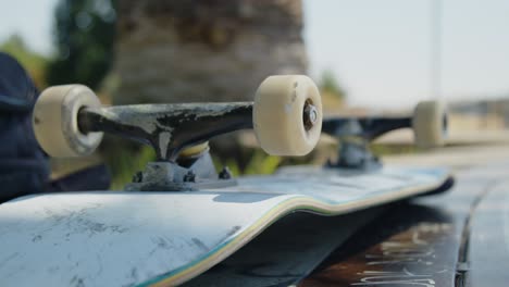 smooth panning shot of an upside-down skateboard resting on a concrete ledge at the skatepark