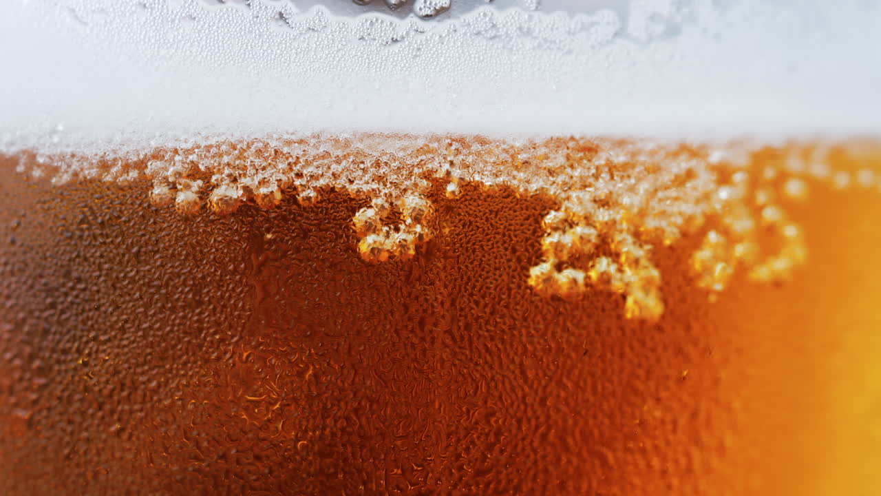 Close up of bubbles forming into foam in a beer glass