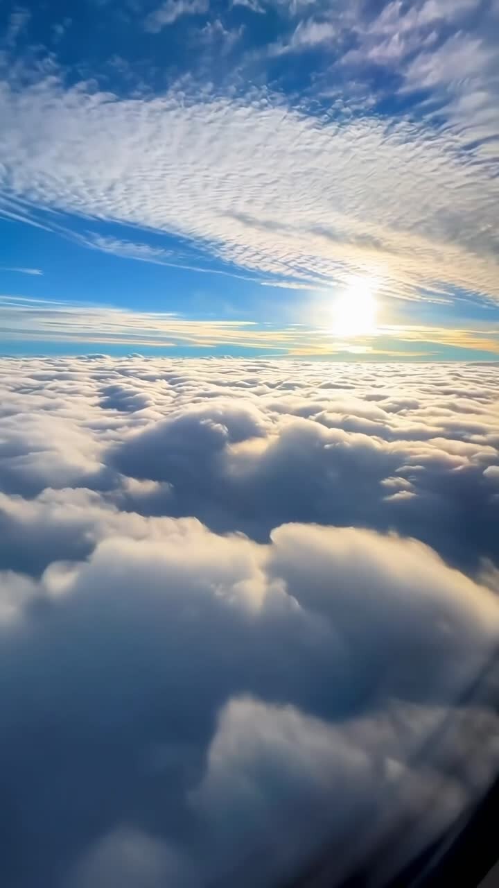 Dronevideo fanger bløde skyer under en levende blå himmel ved solopgang, hvilket skaber en fredfyldt udsigt