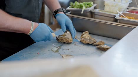 A-cook-opening-a-clam-with-his-knife-in-slow-motion-scene