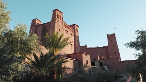 wide view of traditional mud buildings and palm trees in ait ben haddou, morocco