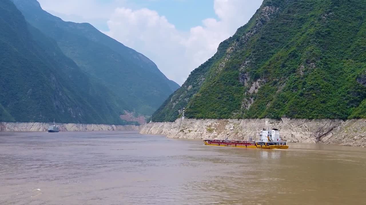 Cargo ship transporting goods, products and vehicles sailing through the gorge on the magnificent Yangtze River, China