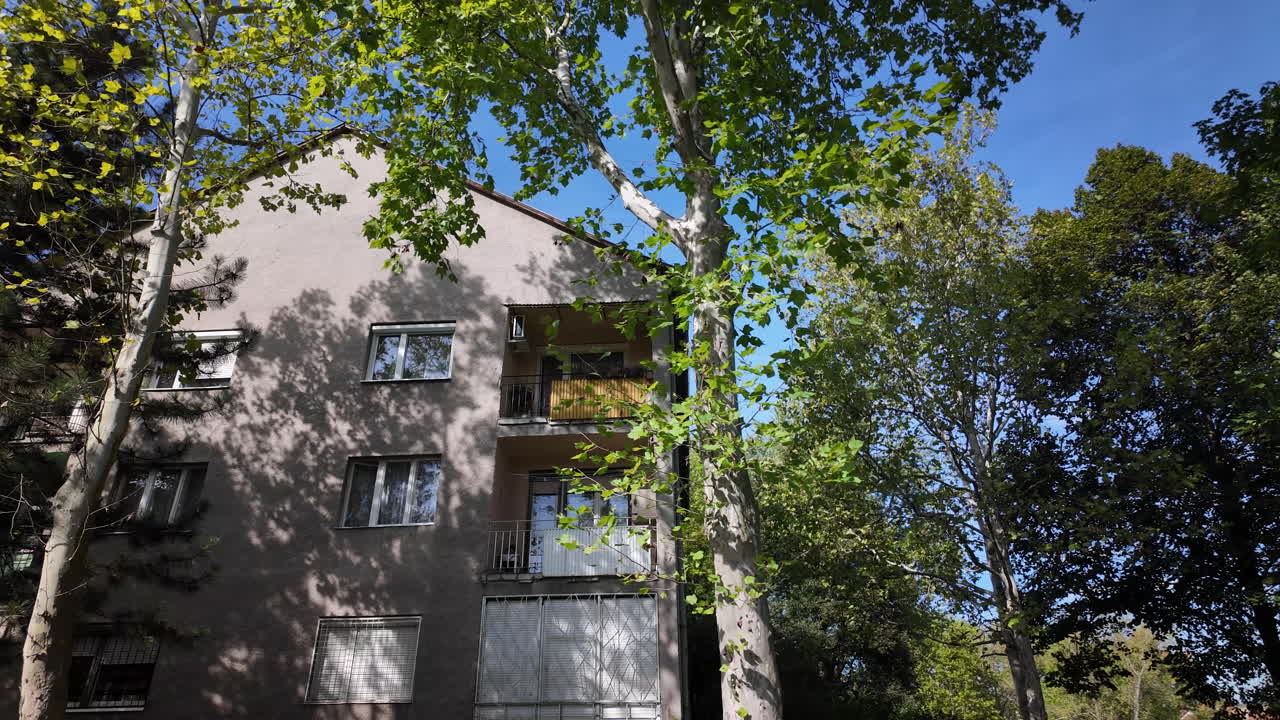 Apartment building surrounded by green trees and grass