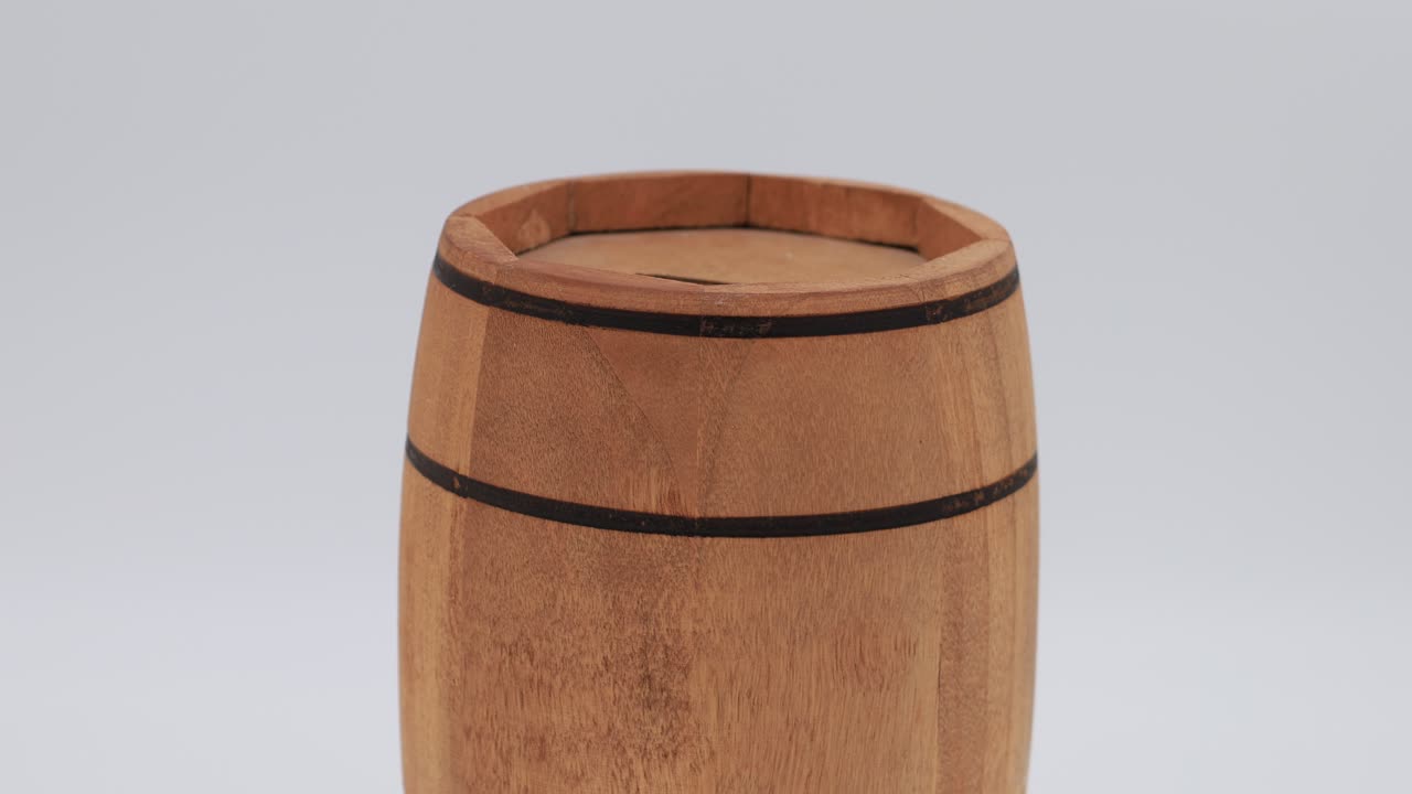 Wooden barrel-shaped money box rotates clockwise