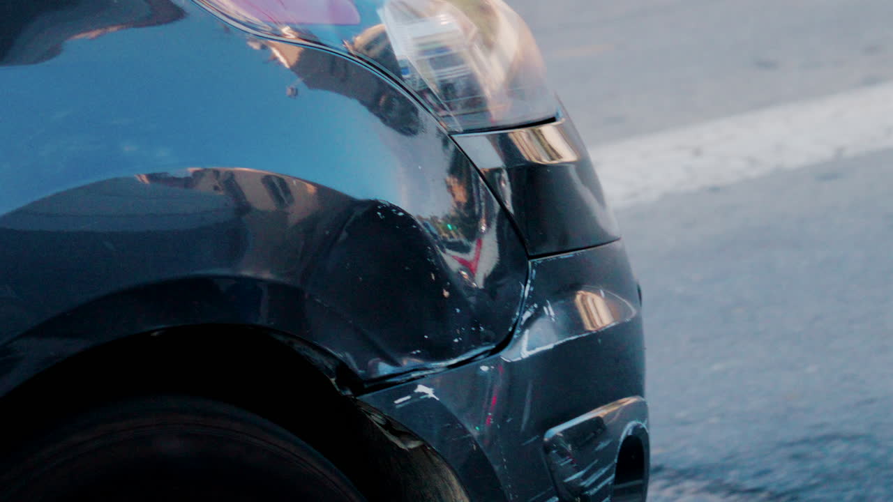 Close up of a scratched and dented car bumper on the street