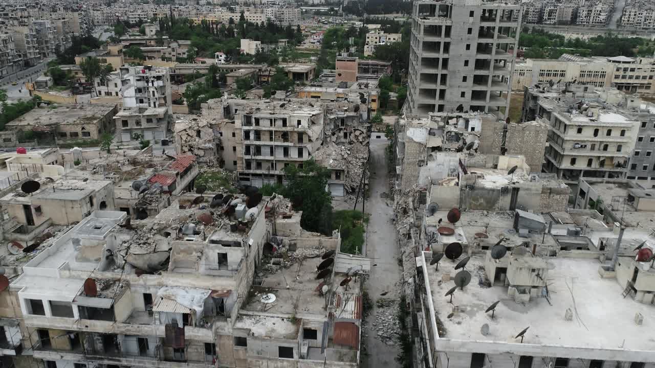 Vista aerea con drone sui tetti degli edifici di Aleppo sotto la luce del sole. Vista dall'alto degli edifici in rovina della città siriana 4K