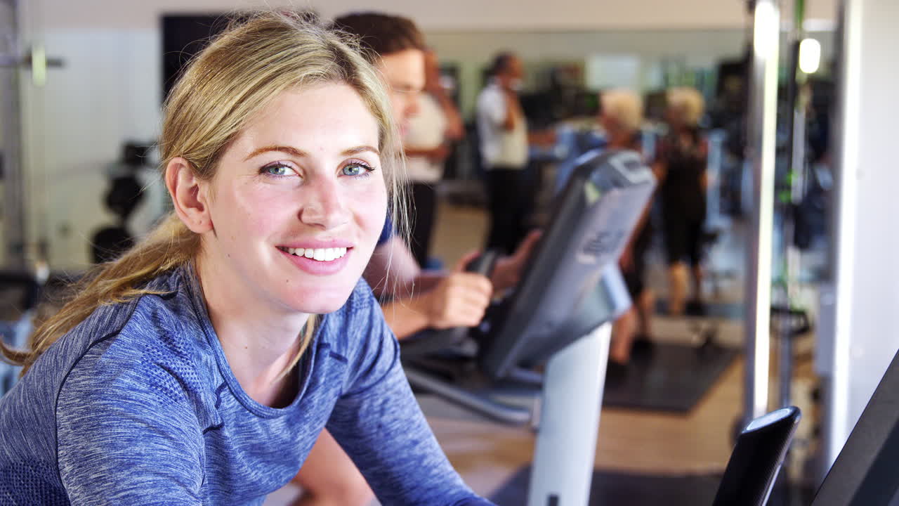 체육관 에서 자전거 기계 에서 운동 을 한 후 휴식 하는 활동적 인 여자 의 초상화