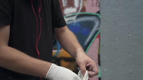 Wearing-latex-gloves-before-painting-a-wall