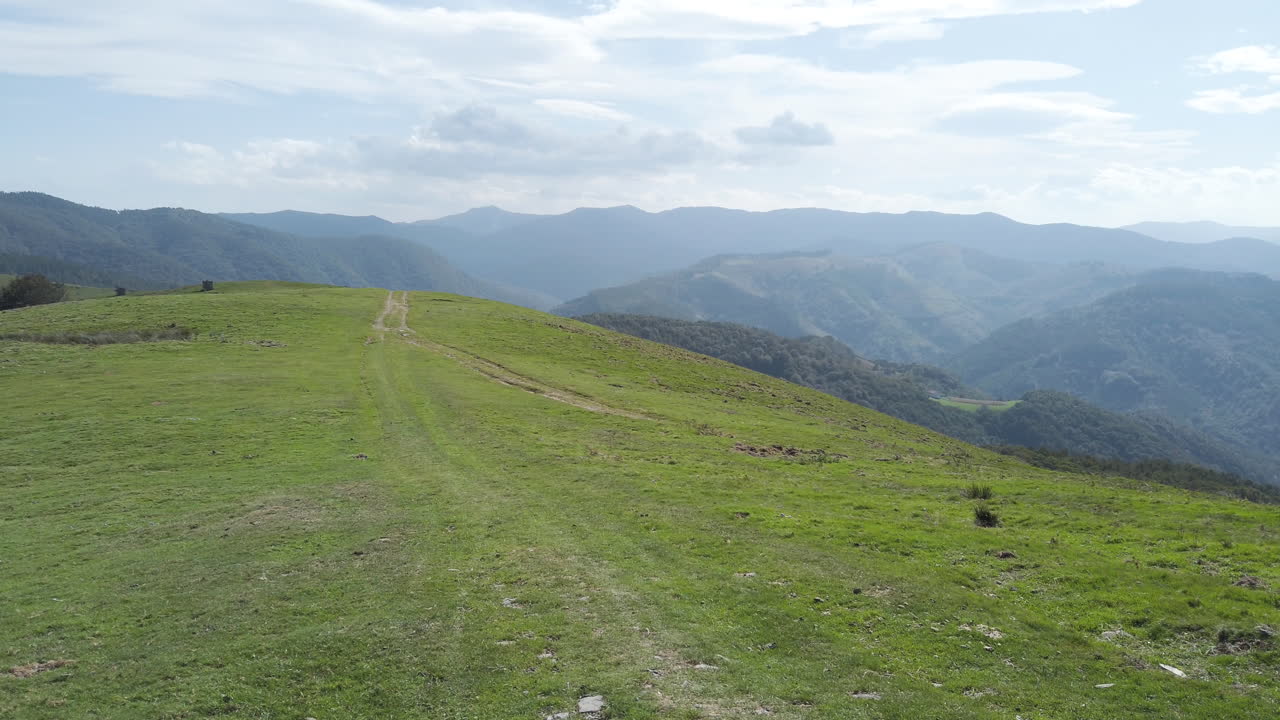 Scenic mountain landscape with green hills and a dirt road