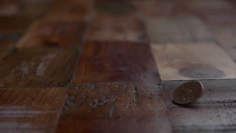 coin bounces on the wooden floor. close up