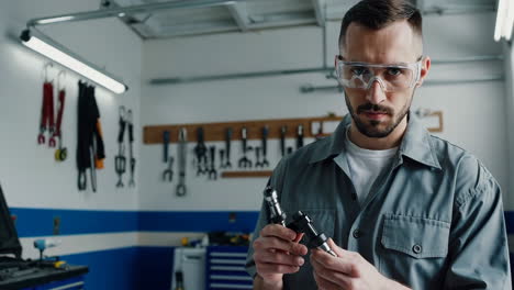 mechanic in workshop holding tools