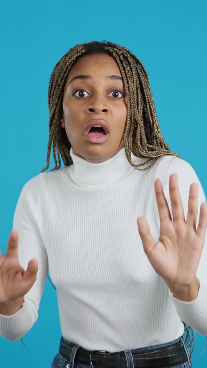 Woman showing a stop gesture with a scared or surprised expression